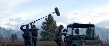 A man holding a mic boom over a filming scene from the documentary, "Tea Creek".